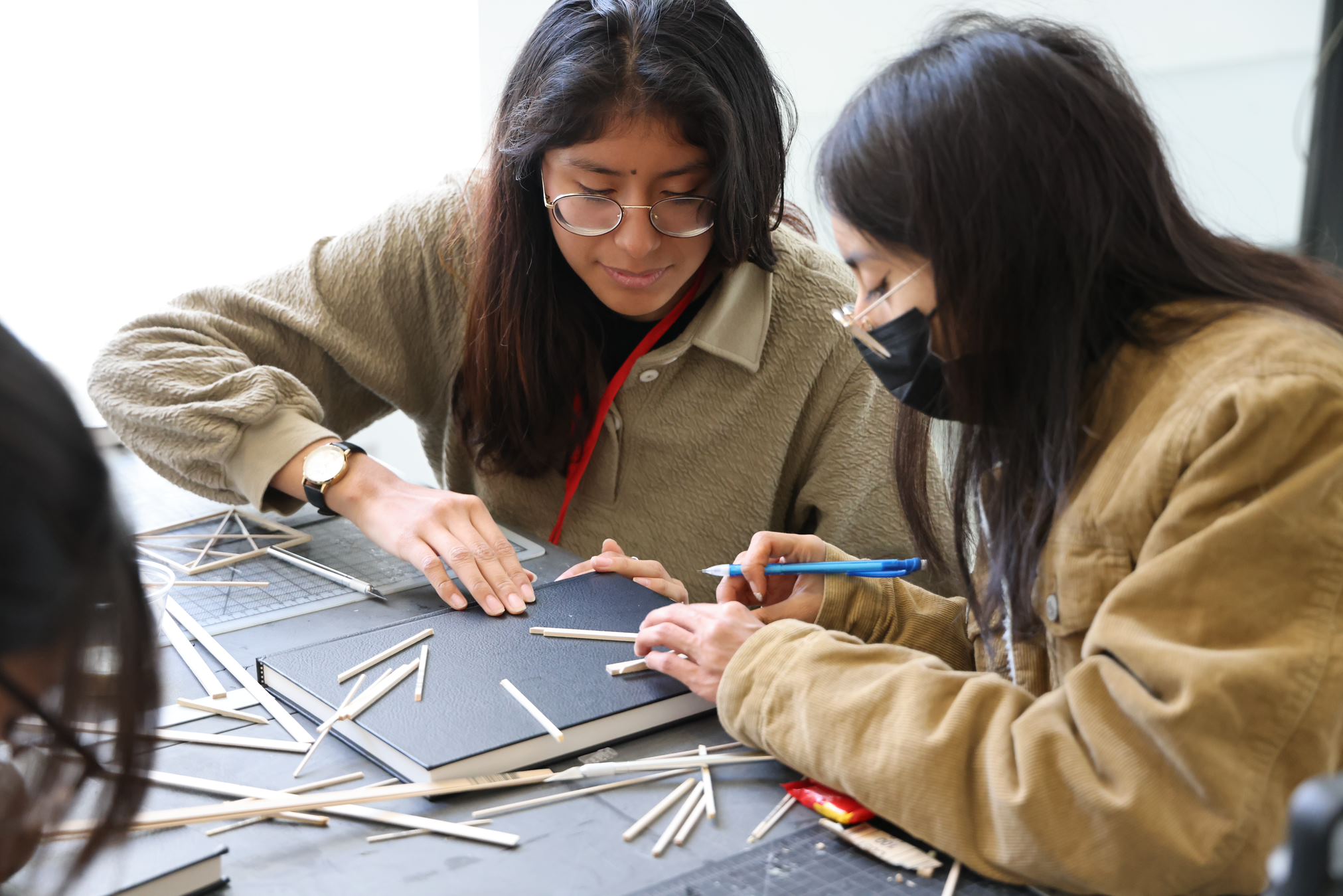 Architecture students making a basswood model.