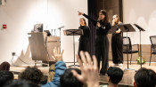 photo of three people on stage in school auditorium