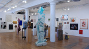 Installation view of gallery with multiple sculptures and art on walls