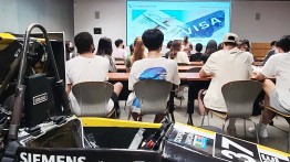a group of students facing a projector screen about the visa process.