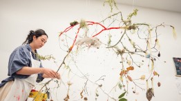 student working on a hanging sculpture