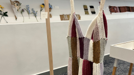 Yarn blanket of many colors in foreground other yarn works in background