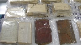 Photo of 19th century letters and wallets in labeled plastic bags