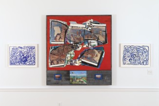 Installation image of three works, two smaller blue prints on each side of a larger mixed media work