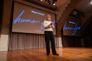 Person on stage with a screen behind