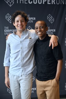 two men hugging in front of a Cooper Union sign