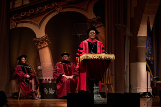 Woman in regalia at lectern