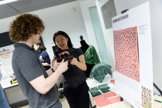 Engineering student shows work and poster on fabric