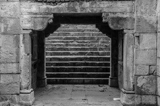 A gallery framed by heavy brackets resting on pilasters in Sindhvai Maata vaav at Hatkeshwar, Ahmedabad. 