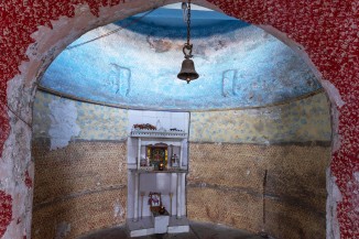 A goddess shrine has been installed in the rear wall of the well shaft at the Gandharva vaav in Saraspur, Ahmedabad. The walls have been painted and a prayer bell has been installed on the underside of a concrete slab covering the formerly open well shaft