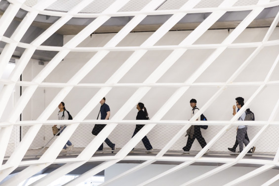 Students cross the lattice bridge inside 41 Cooper Square.
