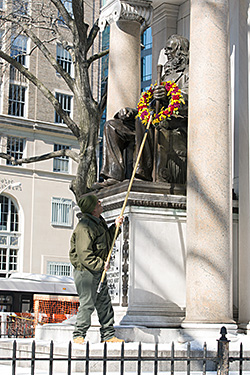 A parks department employee lays the annual wreath